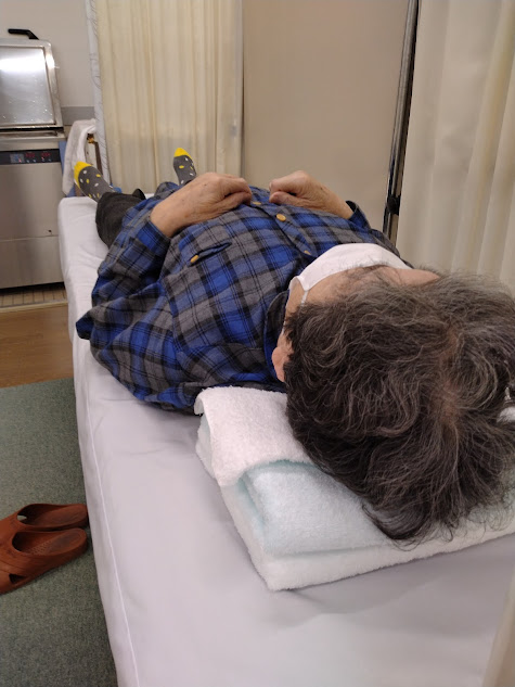 患部の膝の温熱治療を受ける母