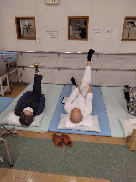 患部の膝をサポートするため、足を伸ばすストレッチの指導を理学療法士の先生から受ける母