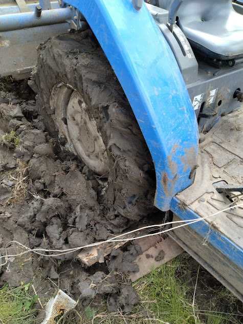 ジェラート状になった後輪タイヤの溝に詰まった泥を枝木で取り除いた様子