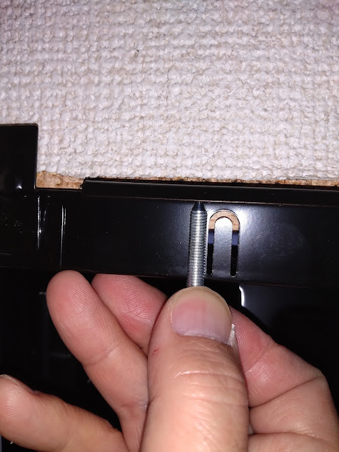 新換気扇のネジを旧換気扇のネジ穴の位置に合わせようと試行錯誤してる様子