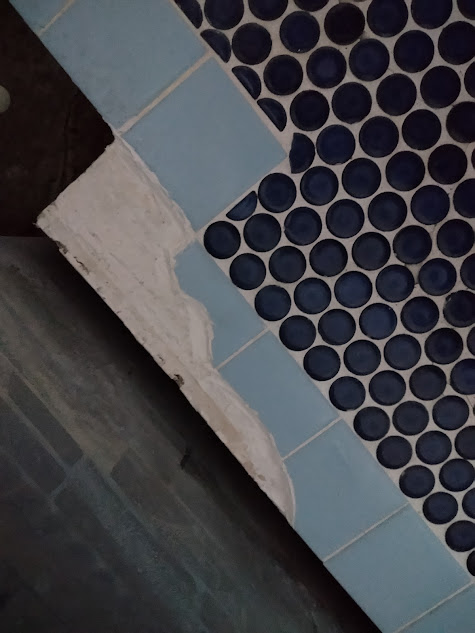 割れたタイルの周辺を清掃