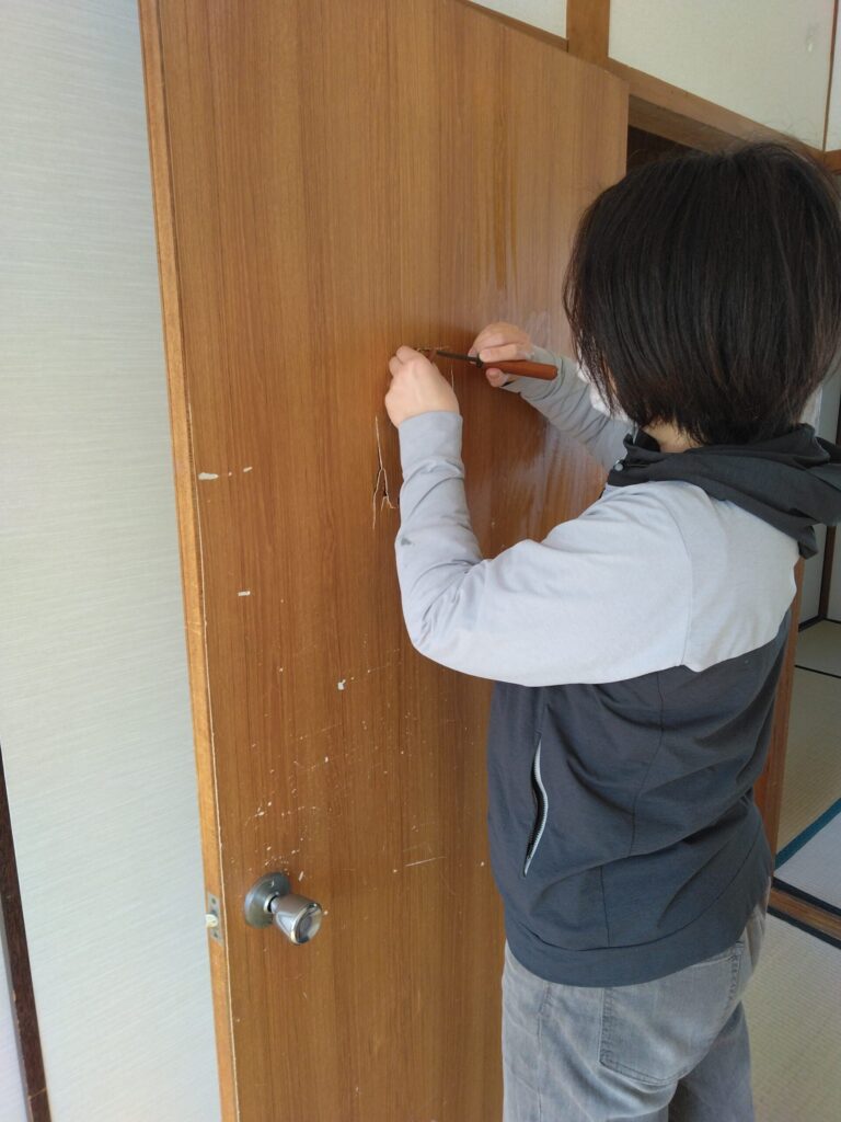 パンチ穴の出っ張った部分をキリを使い、押し込めたり引っ張ったりして平らにしていきます