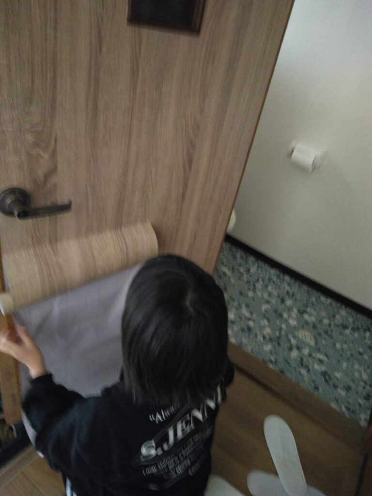途中から娘が加勢し、トイレドアにリメイクシートを貼っていきました。