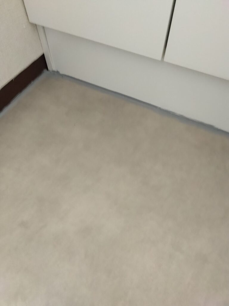 洗面台の設置面含めコーキングを塗り、整っていないところは指で仕上げる