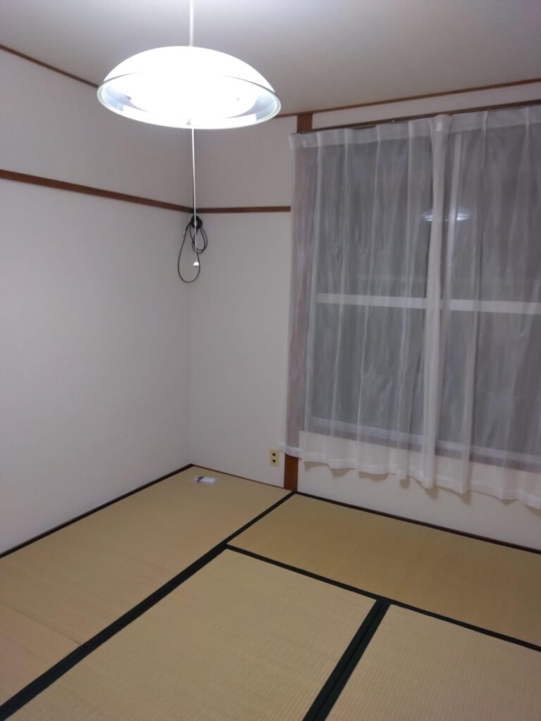 カーテンレールを取り付けた正面窓に入居者の方4がカーテンを設置