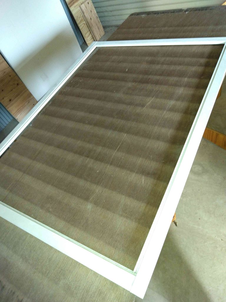 腰の高さの作業台に網戸を載せて腰に負担がなるべくかからないようにして作業します。